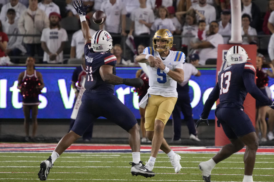 UCLA quarterback Collin Schlee (9) throws a pass over Arizona linebacker Taylor Upshaw (11) during the first half of an NCAA college football game Saturday, Nov. 4, 2023, in Tucson, Ariz. (AP Photo/Rick Scuteri)
