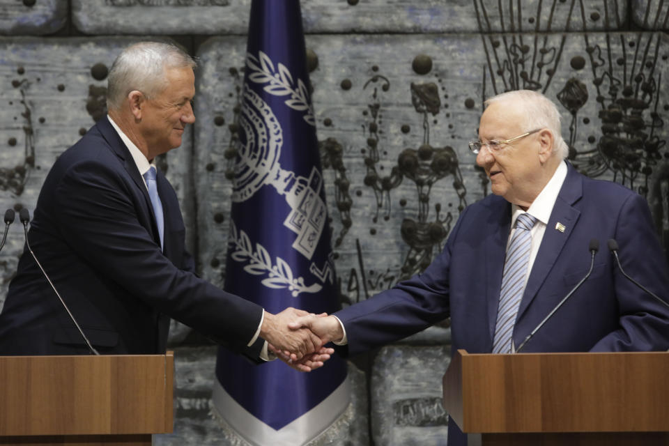 Israeli President Reuven Rivlin, right, shakes hands with Blue and White Party leader Benny Gantz iafter he gave Gantz a mandate to form new government in Jerusalem, Wednesday, Oct. 23, 2019. (AP Photo/Sebastian Scheiner)