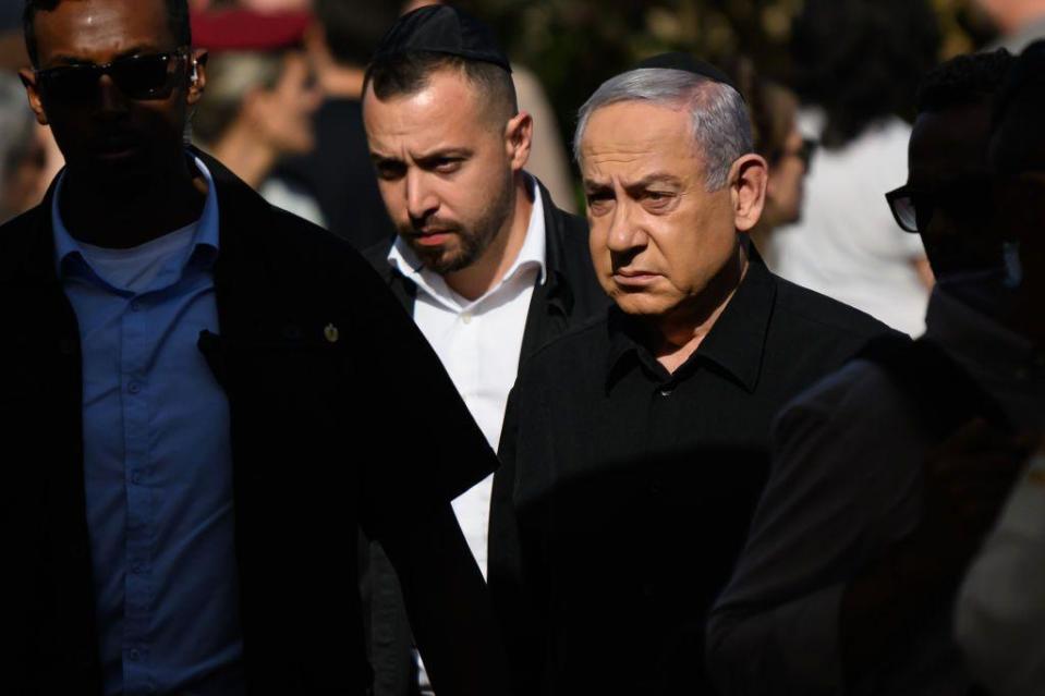 Netanyahu, cariacontecido, con otras dos personas en el funeral de un militar israelí. 