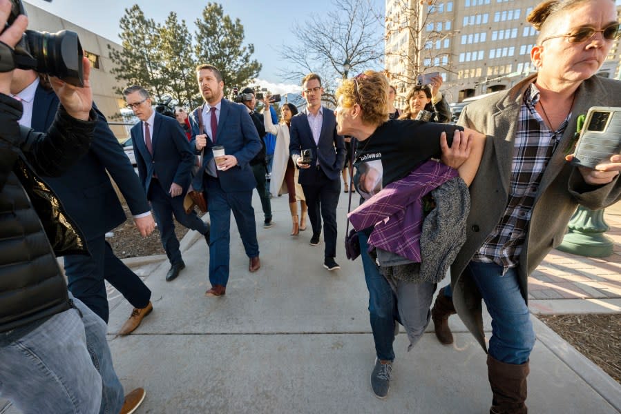 Chrystina Page, right, hold back Heather De Wolf, as she yells at Jon Hallford, left, the owner of Back to Nature Funeral Home, as he leaves with his lawyers following a preliminary hearing, Thursday, Feb. 8, 2024, outside the El Paso County Judicial Building in Colorado Springs, Colo. Hallford and his wife, Carie Hallford, are each charged with 190 counts of abuse of a corpse, five counts of theft, four counts of money laundering and over 50 counts of forgery. De Wolf and Hallford are mothers of sons believed to be among the bodies found at the funeral home. (Christian Murdock/The Gazette via AP)