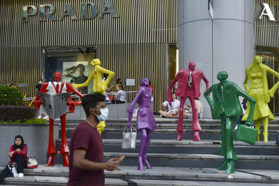 People wearing protective face masks walk along the Orchard Road shopping area in Singapore on Nov. 28, 2021. When Singapore embarked upon its strategy of “living with COVID,” backed by one of the world's leading vaccine programs, the wealthy city-state saw a spike in its rate of infections, leading many to question whether the time was right. (AP Photo/Annabelle Liang)