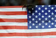 Part of Allyson Felix's hair is seen on top of her national flag, the U.S. flag, as she celebrates winning gold in the women's 200m final during the London 2012 Olympic Games at the Olympic Stadium August 8, 2012. REUTERS/Dylan Martinez (BRITAIN - Tags: OLYMPICS SPORT ATHLETICS TPX IMAGES OF THE DAY) 