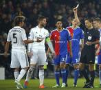 Referee Milorad Mazic (R) shows a yellow card to Real Madrid's Fabio Coentrao (L) during their Champions League Group B soccer match at St. Jakob-Park stadium in Basel November 26, 2014. REUTERS/Ruben Sprich