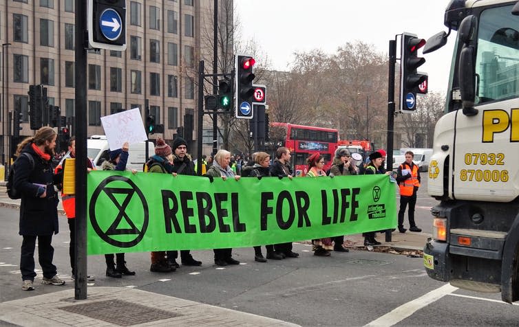 Protestors carry a banner reading 'Rebel For Life'