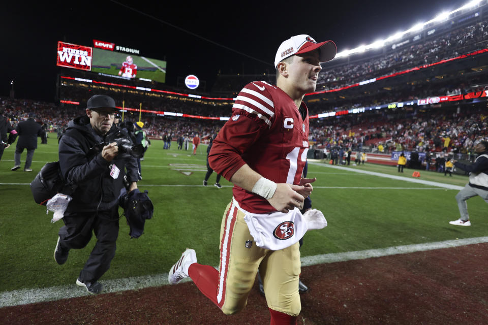 San Francisco 49ers quarterback Brock Purdy (13) runs off the field after a win over the Green Bay Packers in an NFL football NFC divisional playoff game Saturday, Jan. 20, 2024, in Santa Clara, Calif. (AP Photo/Jed Jacobsohn)