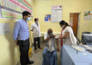 District magistrate Sanjeev Singh, left, overlooks a health worker administering vaccine to a villager at Naugarh, Uttar Pradesh state, India, on June 10, 2021. India's vaccination efforts are being undermined by widespread hesitancy and fear of the jabs, fueled by misinformation and mistrust. That's especially true in rural India, where two-thirds of the country’s nearly 1.4 billion people live. (AP Photo/Rajesh Kumar Singh)