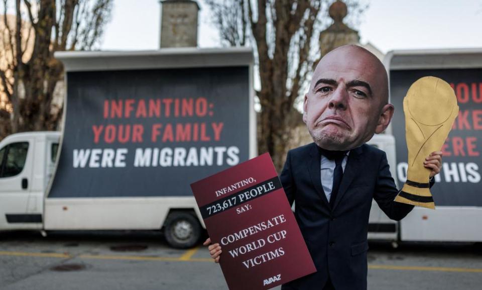 An activist wearing a Gianni Infantino mask calls for Fifa to set up a compensation fund for the families of migrant workers who died on World Cup sites.