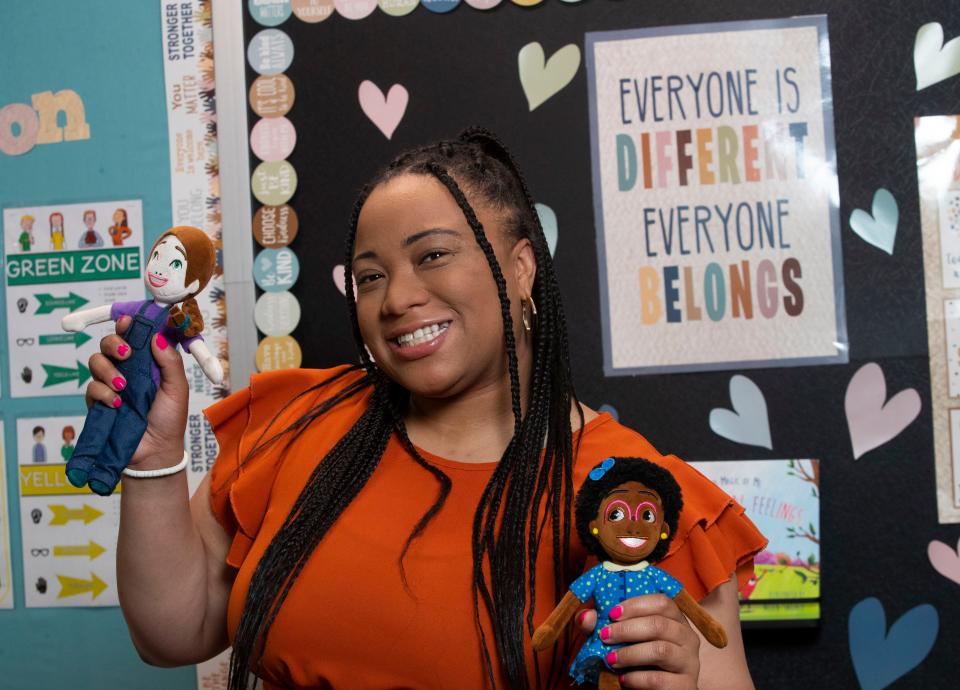 Tahiya Cooper, a school counselor at Holly Hall Elementary School in Elkton, Maryland, has released a children's book - her second - inspired by the "kindness club" in the fifth-grade class she taught. She's pictured at the school with dolls of two characters from "The Sunshine Rock," Tuesday, May 16, 2023.