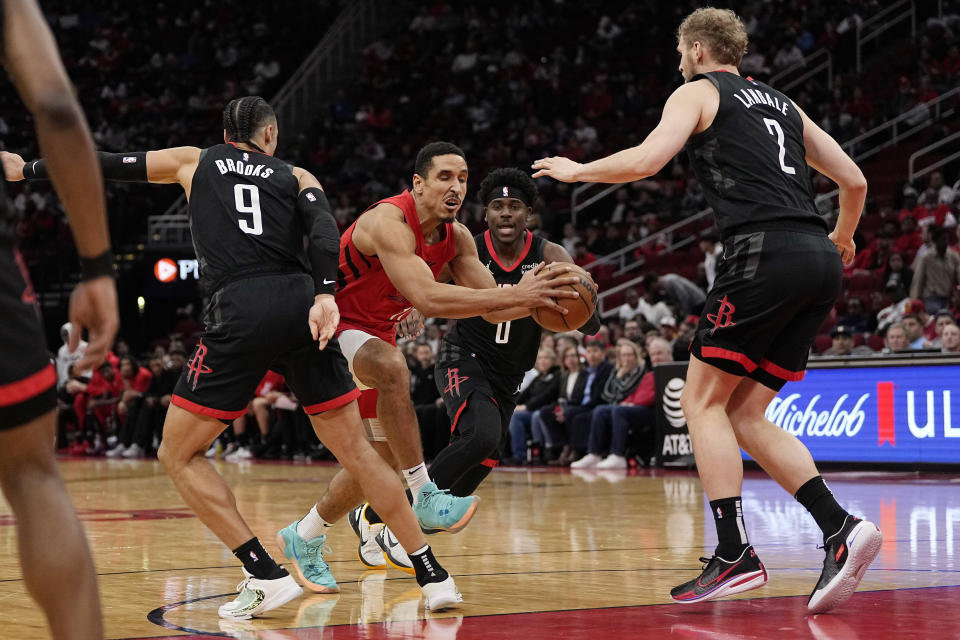 Portland Trail Blazers guard Malcolm Brogdon tries to get past the Houston Rockets defense during the second quarter of an NBA basketball game, Wednesday, Jan. 24, 2024, in Houston. (AP Photo/Kevin M. Cox)