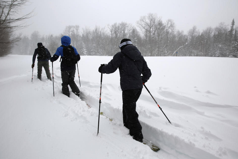 Back country ski guide John Beattie, of Umiak Outdoors, leads Amherst College students Dan Dachille, center, Allison Lounsbury, while cross country skiing in the Sterling Valley area of Stowe, Vt., Wednesday March 15, 2023. They were taking advantage of the new snow that fell across the region. (AP Photo/Wilson Ring)