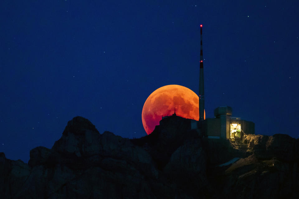 <p>The moon turns red during a total lunar eclipse, behind the Saentis in Luzern, Switzerland, Friday, July 27, 2018. (Photo: Christian Merz/Keystone via AP) </p>