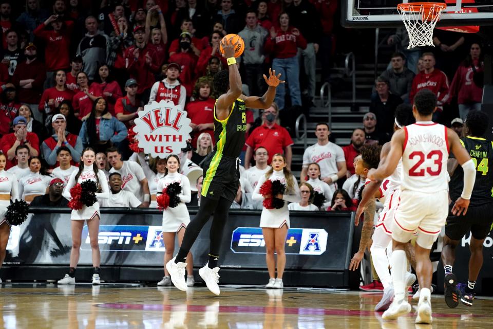 South Florida Bulls center Russel Tchewa (54) scores the game-winning basket as time expires in the second half of a men's NCAA basketball game against the Cincinnati Bearcats, Saturday, Feb. 26, 2022, at Fifth Third Arena in Cincinnati. The South Florida Bulls won, 54-52.