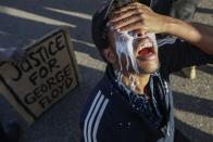 FILE - In this May 29, 2020, file photo, a protester reacts after being pepper sprayed by police and receiving a sodium bicarbonate mixture from fellow demonstrators to help neutralize the effect, in St. Paul, Minn. Former Minneapolis police Officer Derek Chauvin faces decades in prison when he is sentenced Friday for murder in the May 2020 death of George Floyd. Floyd's death, filmed by a teenage bystander as Chauvin pinned Floyd to the pavement for about 9 and a half minutes and ignored Floyd's "I can't breathe" cries until he eventually grew still, reignited a movement against racial injustice that swiftly spread around the world and continues to reverberate.(AP Photo/John Minchillo, File)