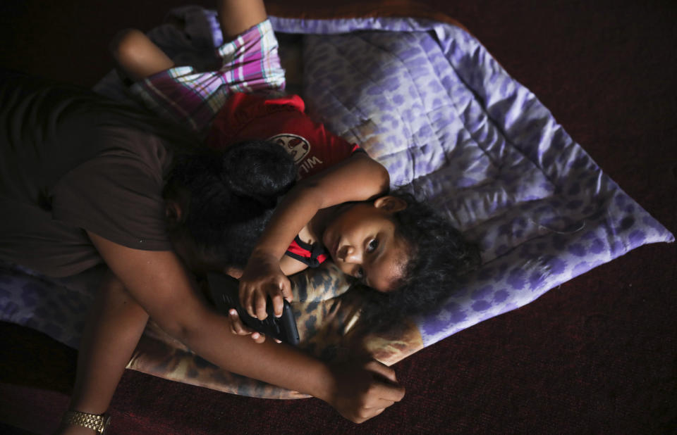 A young migrant from Cuba looks up at the camera inside Viento Recio church, serving as a migrant shelter in Matamoros, Mexico, Thursday, Aug. 1, 2019, on the border with Brownsville, Texas. The United States government has sent some 800 mostly Central American and Cuban immigrants back to this northern Mexico border city since expanding its controversial plan to this easternmost point on the shared border two weeks ago, according to local Mexican authorities. (AP Photo/Emilio Espejel)