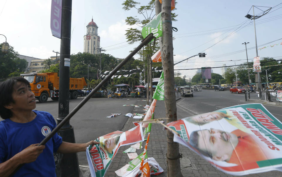 A Manila City public worker removes the campaign posters, mostly that of incumbent Mayor and former President Joseph "Erap" Estrada around the Manila City Hall, a day after the country's midterm elections Tuesday, May 14, 2019 in Manila, Philippines. Estrada lost his third term mayoral bid along with four of his children who ran in local polls, ending his 50-year-dominance in two metropolitan cities in the country. Two of his sons, who ran for senators, are also clinging to the last senate slot in initial results, which were dominated by President Rodrigo Duterte's allies. (AP Photo/Bullit Marquez)