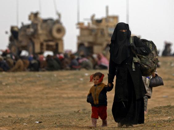 Civilians flee the last Isis enclave in Baghouz as Syrian Democratic Forces battle to liberate the village (AFP/Getty)