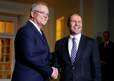 The new Australian Prime Minister Scott Morrison shakes hands with the new Treasurer Josh Frydenberg after the swearing-in ceremony in Canberra, Australia August 24, 2018. REUTERS/David Gray/Files