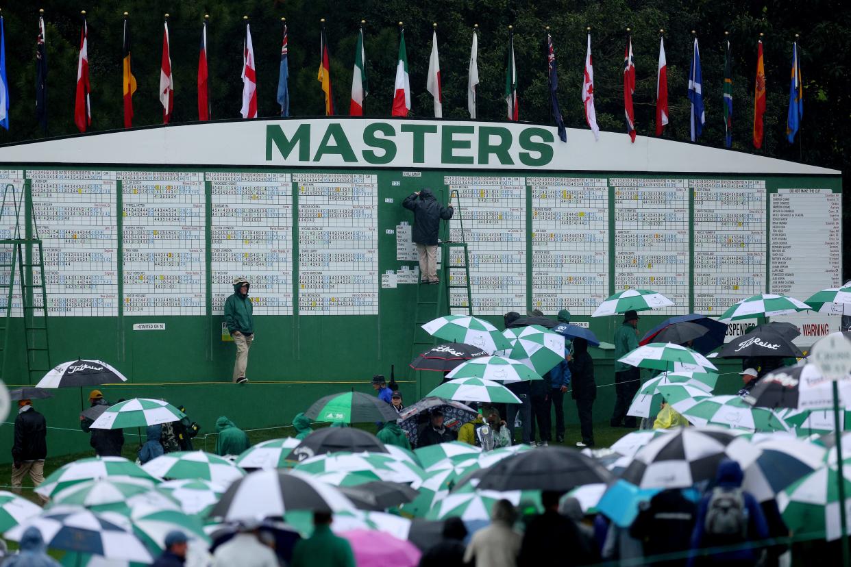 Patrons leave the grounds after play was suspended for the day due to rain in the third round of the Masters.