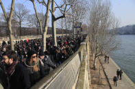 People march along the Seine river during a demonstration, Friday, Jan. 24, 2020 in Paris. French unions are holding last-ditch strikes and protests around the country Friday as the government unveils a divisive bill redesigning the national retirement system. (AP Photo/Michel Euler)