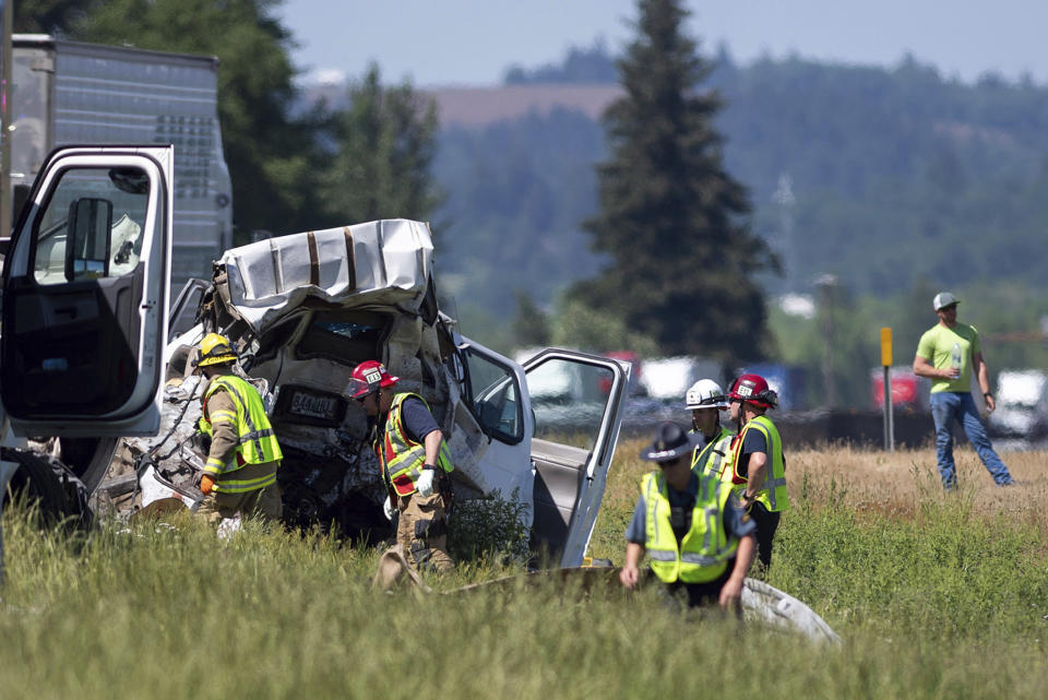 Oregon State Police troopers and firefighters work near the site of a wrecked tractor-trailer (Alex Powers / Albany Democrat-Herald via AP)