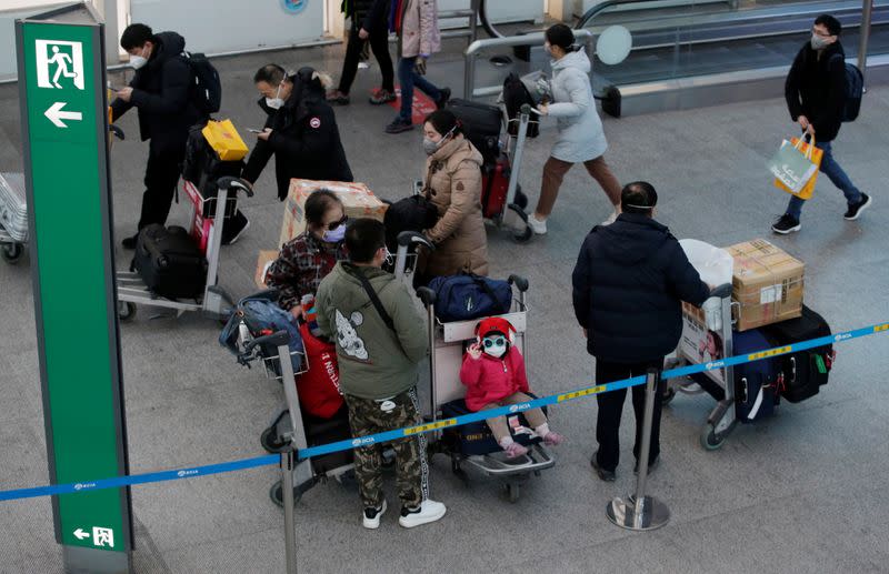 Travellers wearing masks are seen at Beijing International Airport in Beijing