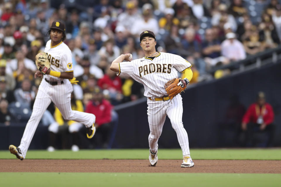 San Diego Padres third baseman Ha-Seong Kim, right, throws out Miami Marlins' Bryan De La Cruz at first base in the fourth inning of a baseball game as C.J. Abrams, background, looks on, Saturday, May 7, 2022, in San Diego. (AP Photo/Derrick Tuskan)