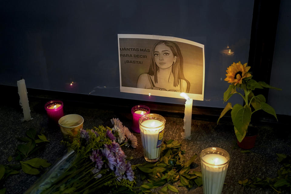 Candles and flowers surround an image of Debanhi Escobar during a protest against the disappearance of Escobar and other women who have gone missing, at the Attorney General's office in Mexico City, Friday, April 22, 2022. The protest against femicide was triggered after Escobar's decomposing body was recently found in a subterranean water tank at a motel when workers reported foul odors coming from the water holding tank. (AP Photo/Eduardo Verdugo)