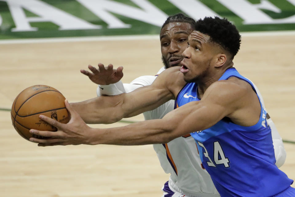 Milwaukee Bucks' Giannis Antetokounmpo, right, is fouled by Phoenix Suns' Jae Crowder, left, during the first half of an NBA basketball game Monday, April 19, 2021, in Milwaukee. (AP Photo/Aaron Gash)