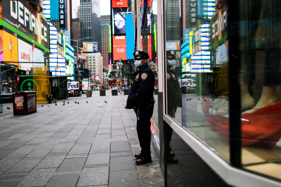 A New York Police officer stands guard in an almost empty Times Square during the outbreak of the coronavirus disease (COVID-19) in New York City, U.S., March 31, 2020  REUTERS/Eduardo Munoz