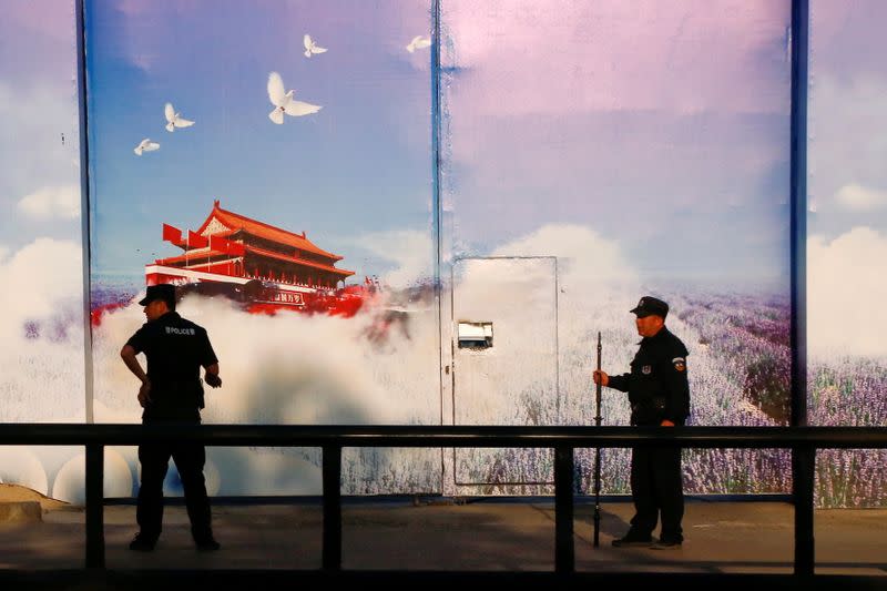 FILE PHOTO: Security guards stand at the gates of what is officially known as a vocational skills education centre in Huocheng County in Xinjiang Uighur Autonomous Region