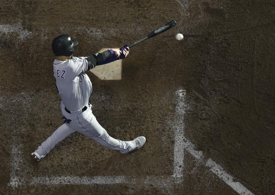 Colorado Rockies' Carlos Gonzalez hits a triple during the fifth inning of Game 1 of the National League Divisional Series baseball game against the Milwaukee Brewers Thursday, Oct. 4, 2018, in Milwaukee. (AP Photo/Morry Gash)