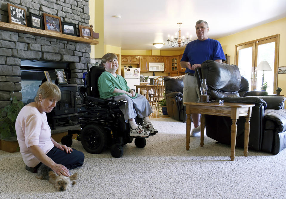 FILE - This undated photo shows Terry Horgan with his parents at home in Montour Falls, N.Y. Horgan, 27, the lone volunteer in a gene-editing study targeting a rare form of Duchenne muscular dystrophy, likely died after having a reaction to the virus that delivered the therapy in his body, researchers concluded in an early study released in May 2023. (Kate Collins/The Journal via AP, File)