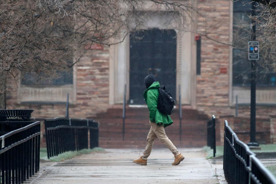A lone pedestrian moves through the closed campus of the University of Colorado as a statewide stay-at-home order remains in effect in an effort to reduce the spread of the new coronavirus Thursday, April 2, 2020, in Boulder, Colo. The new coronavirus causes mild or moderate symptoms for most people, but for some, especially older adults and people with existing health problems, it can cause more severe illness or death. (AP Photo/David Zalubowski)