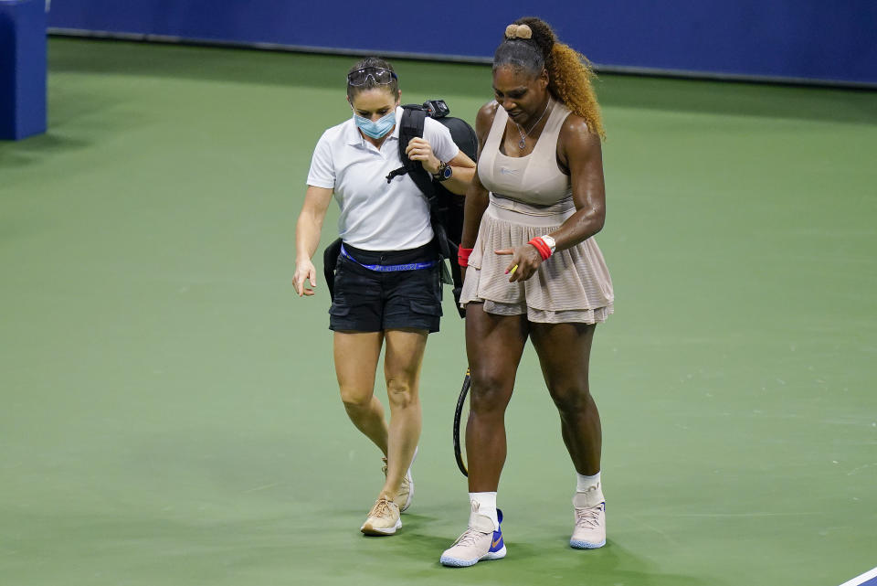 FILE - In this Sept. 10, 2020, file photo, Serena Williams walks to her bench with a trainer for a medical timeout during a semifinal match of the U.S. Open tennis championships, against Victoria Azarenka, of Belarus, in New York. (AP Photo/Seth Wenig, File)