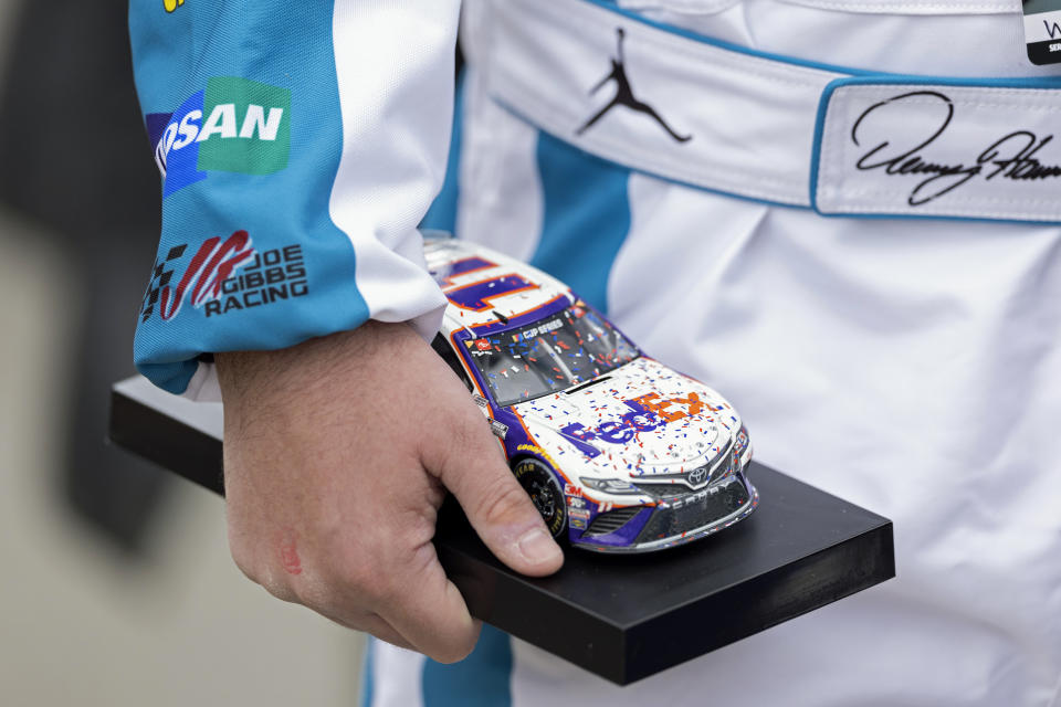 Denny Hamlin fan Will Signor, from Gettysburg, Penn., holds a model car as he waits for an autograph before a NASCAR Cup Series auto race, Sunday, March 17, 2024, in Bristol, Tenn. (AP Photo/Wade Payne)