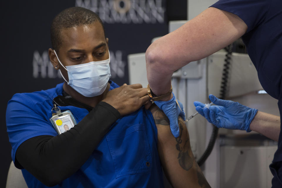 Robert Luckey, COVID ICU Nurse, receives the hospital's first dose of the Pfizer-BioNTech vaccine for COVID-19 at Memorial Hermann Hospital in the Texas Medical Center Tuesday, Dec. 15, 2020 in Houston. Front line workers at Memorial Hermann were some of the first to receive the recently approved vaccine. The Pfizer vaccine was almost 95 percent effective at preventing patients from contracting COVID-19 and caused no major side effects in a trial of nearly 44,000 people. (Brett Coomer/Houston Chronicle via AP)