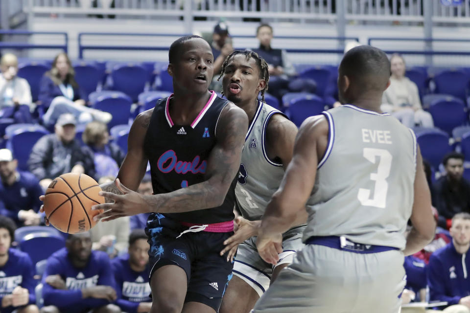 Florida Atlantic guard Johnell Davis, left, looks to pass the ball under pressure from Rice guards Mekhi Mason, center, and Travis Evee (3) during the first half of an NCAA college basketball game Wednesday, Jan. 24, 2024, in Houston. (AP Photo/Michael Wyke)