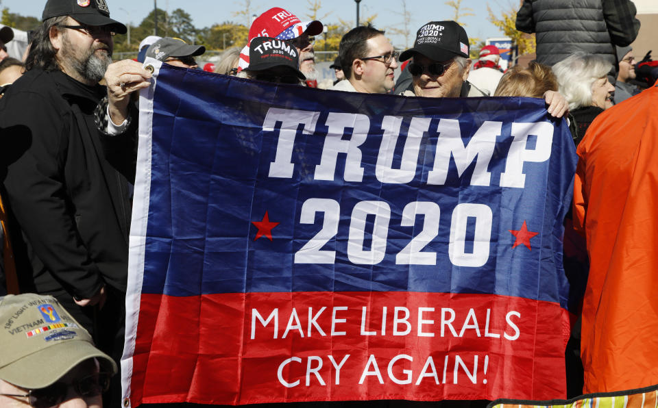 Deborah Aldridge, left, and Arlene Walker, both of Athens, Ala., hold up a President Donald Trump support banner while waiting outside the BancorpSouth Arena in Tupelo, Miss., Friday, Nov. 1, 2019, before a Keep America Great Rally. (AP Photo/Rogelio V. Solis)