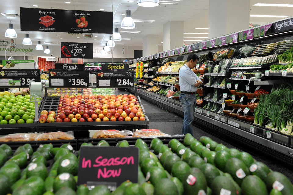 A shopper looks at produce in the fruit and vegetable section inside a Woolworths grocery store in Brisbane.