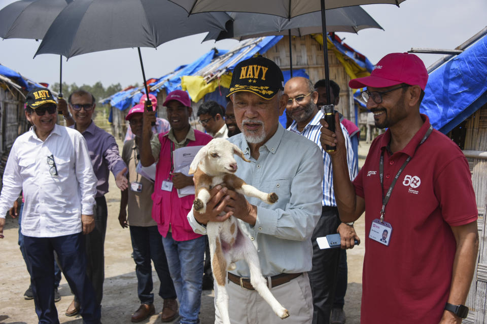 Japanese philanthropic group Nippon Foundation's Chairman Sasakawa Yohei, carries a lamb during a visit to Bhasan Char island in the Bay of Bengal, where thousands of Rohingya refugees are living in Bangladesh, Saturday, April 6, 2024. Japan's Nippon Foundation will spend $2 million to help move tens of thousands more Rohingya refugees to a remote island in Bangladesh and provide them with skills training, Sasakawa said. (Nippon Foundation via AP)