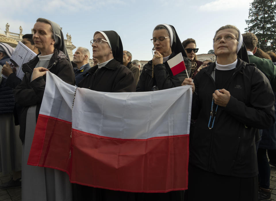 Nuns bearing Polish flags listen to Pope Francis as he appears at his window overlooking St. Peter's Square at The Vatican for the traditional noon blessing, Sunday, Jan. 1, 2023. When addressing the faithful in St. Peter's Square, Francis cited the "intolerable" war in Ukraine, which began in February of last year with Russia's attacks and invasion, and in other places in the world. (AP Photo/Domenico Stinellis)