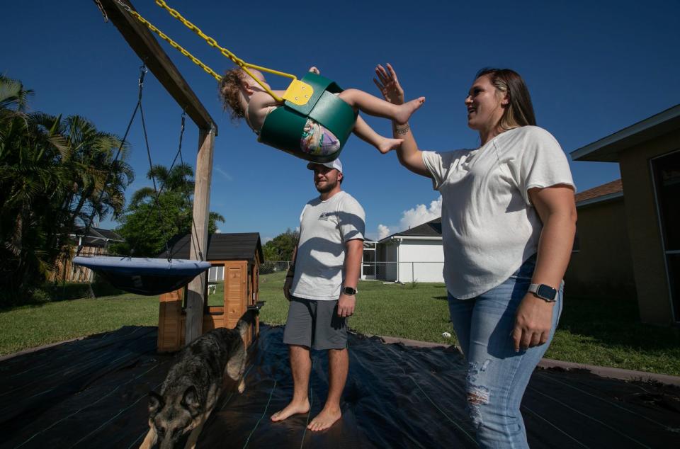 Cape Coral residents and police officers Nicholas Bezanson and Kelsey Meadows play in their backyard home swing set with their daughter Hayden Bezanson, 2, Wednesday, September 13, 2023. Ricardo Rolon/USA TODAY NETWORK-FLORIDA