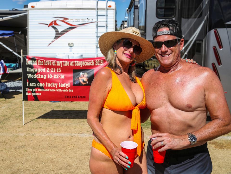 Tara Petrina and husband Bruce Alpern of Laguna Beach pose for a photo together in front of a sign explaining that they met at Stagecoach back in 2013 in their camp during Stagecoach country music festival in Indio, Calif., Saturday, April 27, 2024. Petrina says she was there on a girls' trip and ended up meeting Alpern who was camped just across the way from her group and they spent some time together and exchanged numbers and eventually went on their first date six months later. In February of 2015 they were engaged and got married October of the next year and have kept coming back to the festival since.