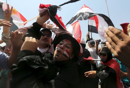 People cheer while carrying national flags in as they gather in Tahrir square to celebrate an extension of the Suez Canal, in Cairo, Egypt, August 6, 2015. REUTERS/Mohamed Abd El Ghany