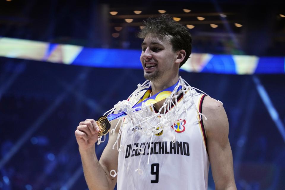 Germany guard Franz Wagner (9) poses with the net and gold medal after defeating Serbia in the championship game of the Basketball World Cup in Manila, Philippines, Sunday, Sept. 10, 2023. (AP Photo/Michael Conroy)