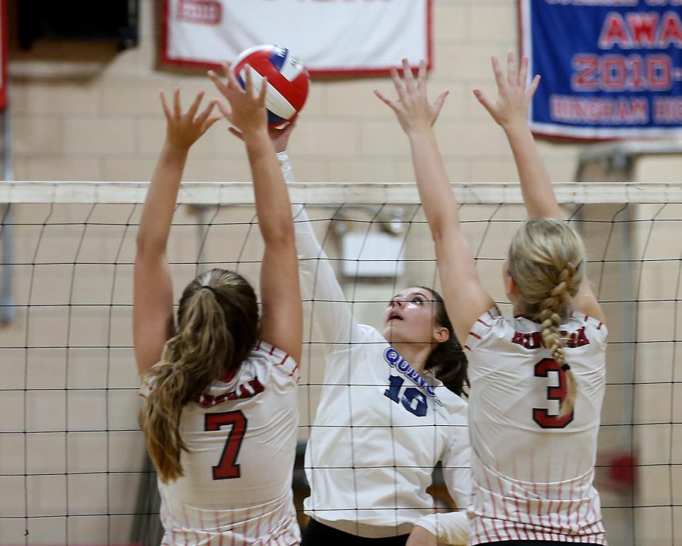 Quincy's Giada Guarino looks to get her return over the arms of Hingham's Lizzie Beyer and Kate DiBartolomeo during second set action of their match against Hingham at Hingham High on Wednesday, Sept. 21, 2022. Quincy would win 3-2.