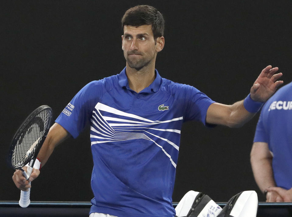 Serbia's Novak Djokovic waves to the crowd after Japan's Kei Nishikori retired injured from their quarterfinal at the Australian Open tennis championships in Melbourne, Australia, Wednesday, Jan. 23, 2019. (AP Photo/Mark Schiefelbein)