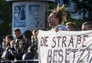 Activists block the main entrance of the fairground in Frankfurt, Germany, Sunday, Sept. 15, 2019. They protest against the government's transport policy on occasion of the IIA Auto Show taking place. The poster reads: 'Occupy the street'. (AP Photo/Michael Probst)