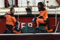 Italian firefighter scuba divers bring ashore, in the green bag, the body of one of the victims from the British-flagged vessel Bayesian, Wednesday, Aug. 21, 2024. The yacht was hit by a violent sudden storm and sank early Monday, while at anchor off the Sicilian village of Porticello near Palermo, in southern Italy. (AP Photo/Salvatore Cavalli)