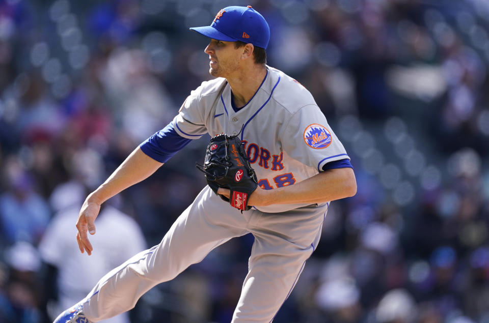 New York Mets starting pitcher Jacob deGrom watches a throw to Colorado Rockies' C.J. Cron during the fourth inning of the first baseball game game of a doubleheader Saturday, April 17, 2021, in Denver. (AP Photo/David Zalubowski)